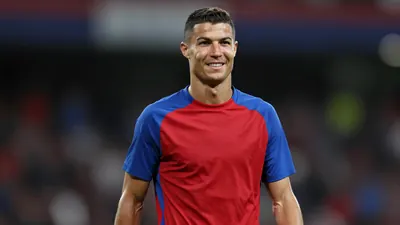 Mid-20s male footballer, athletic build, waist-up, face clear and expressive, wearing a plain, unmarked training top...