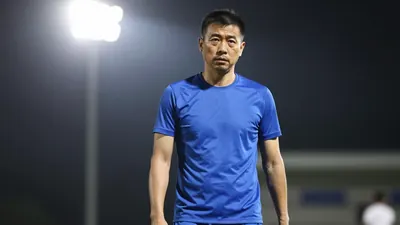 A 35-45 year old male coach with a medium build, wearing a solid blue kit, photographed with an 85mm f/1.4 lens, with a...