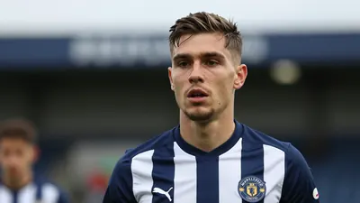 A tight action crop of an anonymous Hartlepool United midfielder in a mid-season match, wearing a navy blue and white...